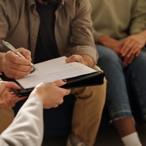 Man signing custody contract at meeting with social worker