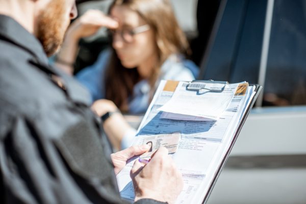 Policeman issuing a fine for a female driver